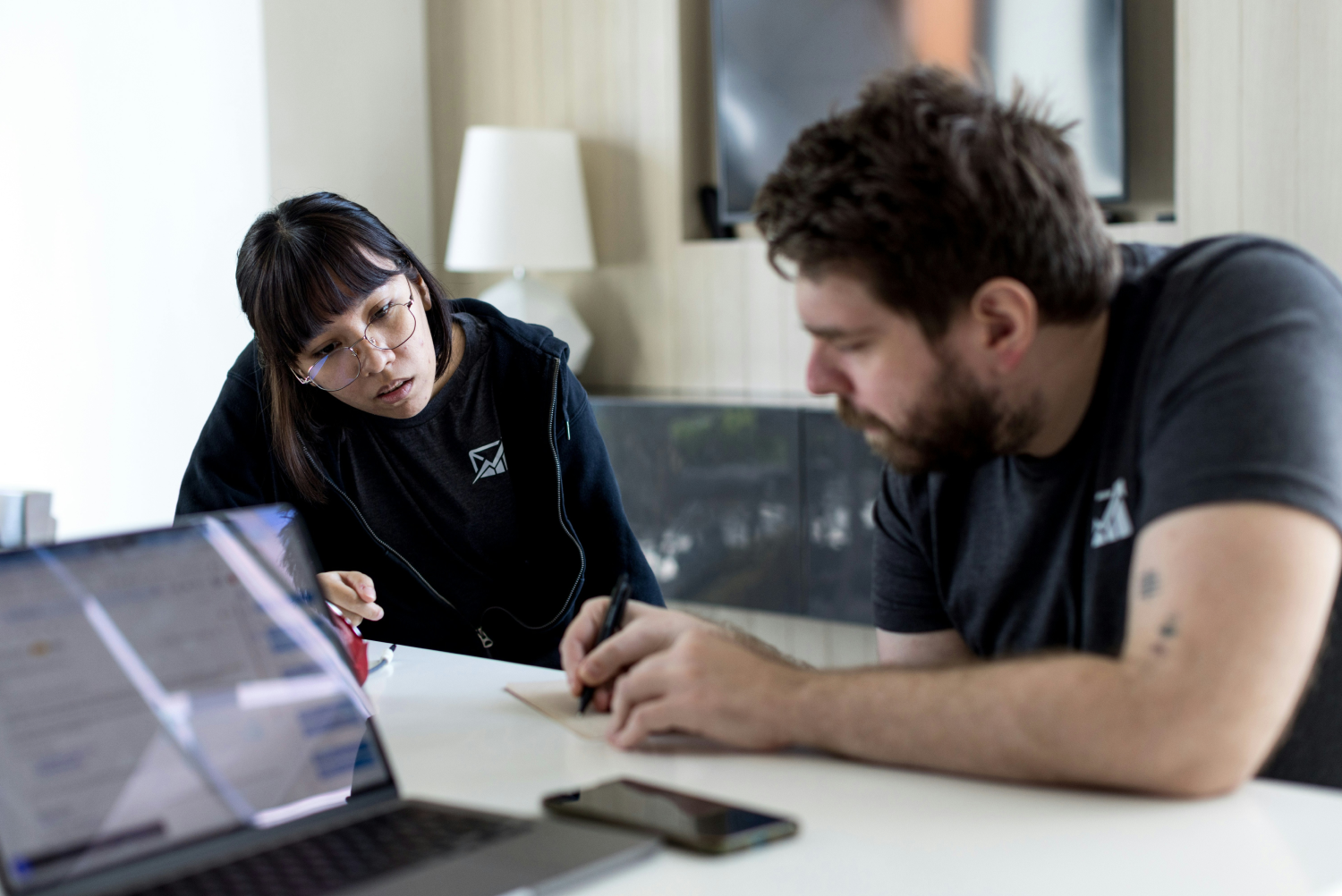 One person explaining something to another using a sketch and verbal