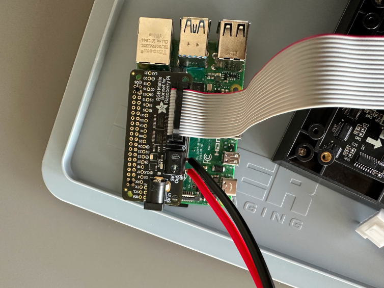 Raspberry pi with a gpio pin hat and a wide cable.