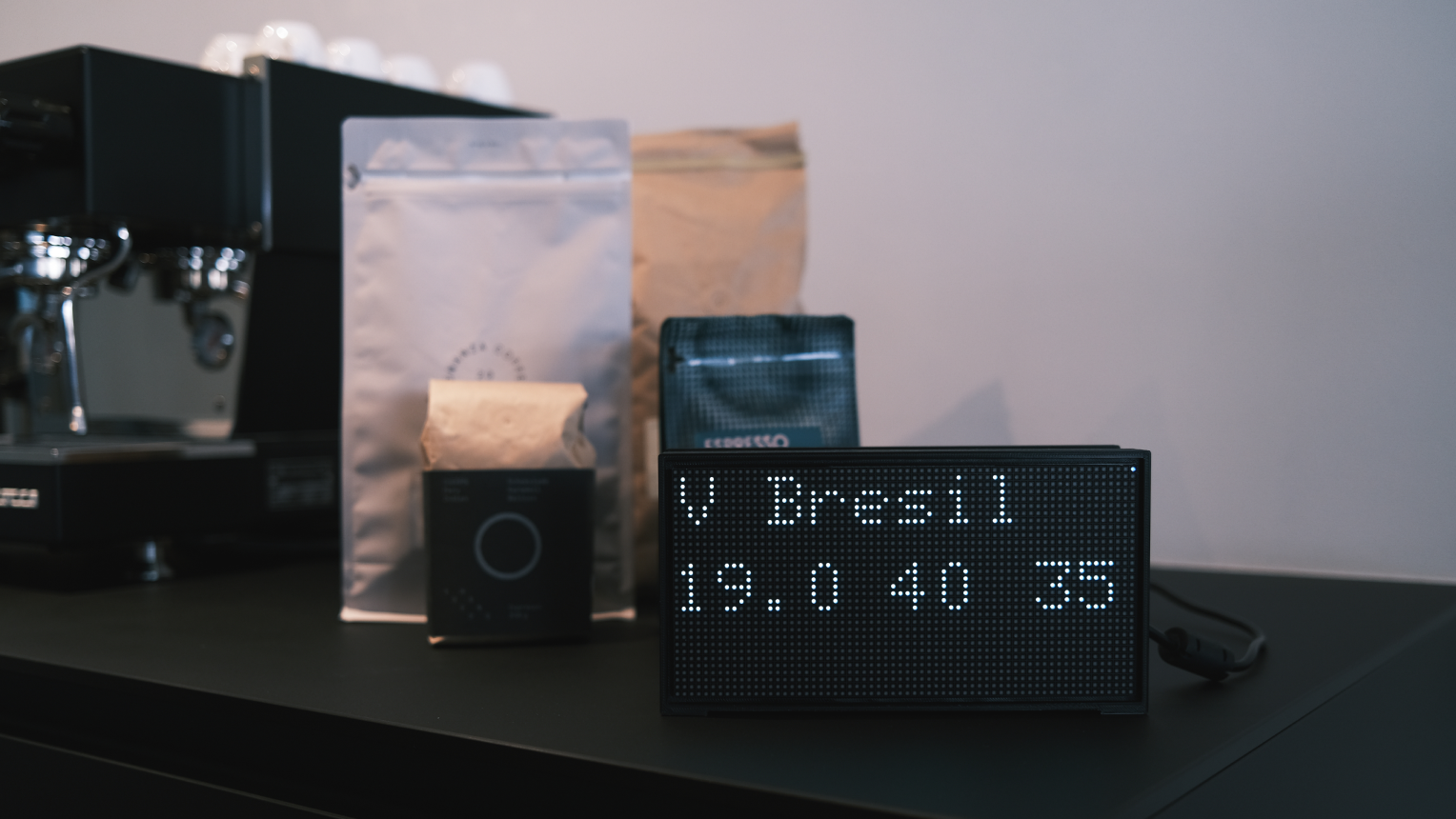 Low resolution led display showing the current coffee recipe standing in front of a group of coffee bags