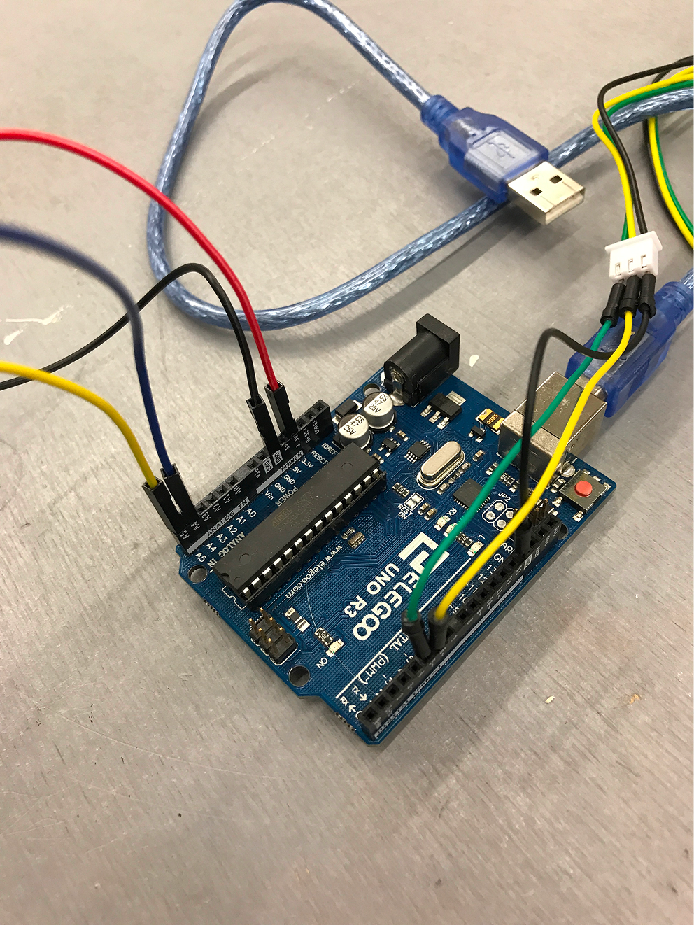 Arduino microcontroller with cables in different colors plugged into its ports