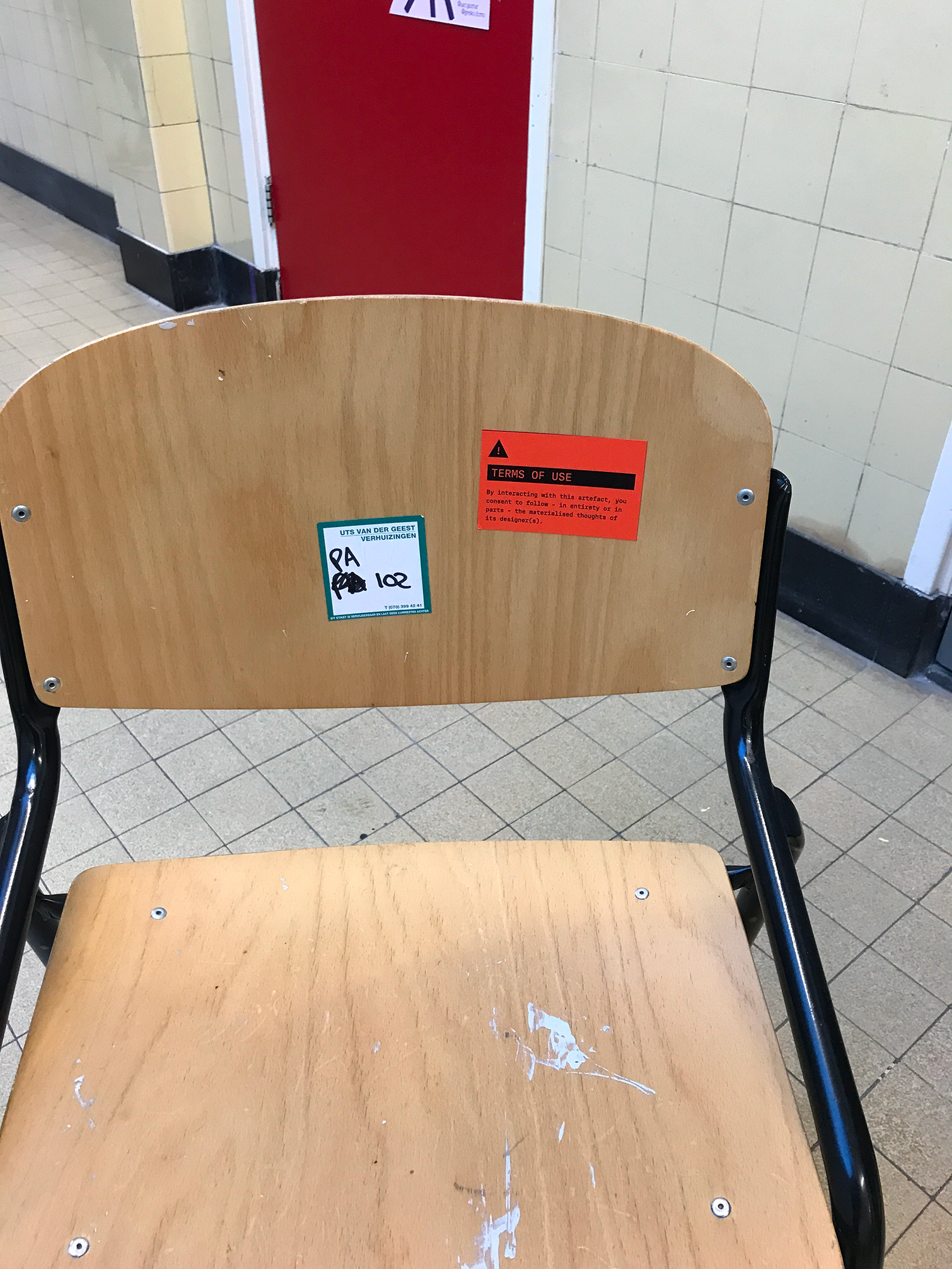 Photo of a bright orange warning sticker placed on a the back of a chair